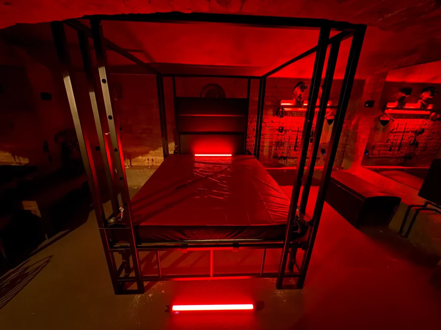Černá kovová bondage postel s úchyty a červeným LED, BDSM studio Vinohrady, Praha 2
