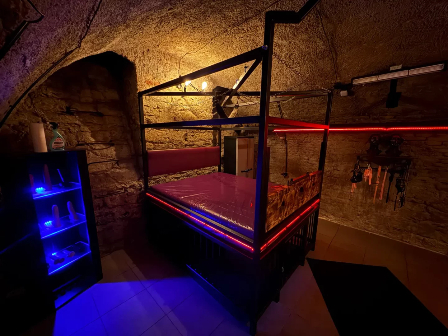 Entspannungslounge mit Neonbeleuchtung, Ledersofa und Blick auf den Spielbereich, BDSM-Studio Karlín, Prag 8