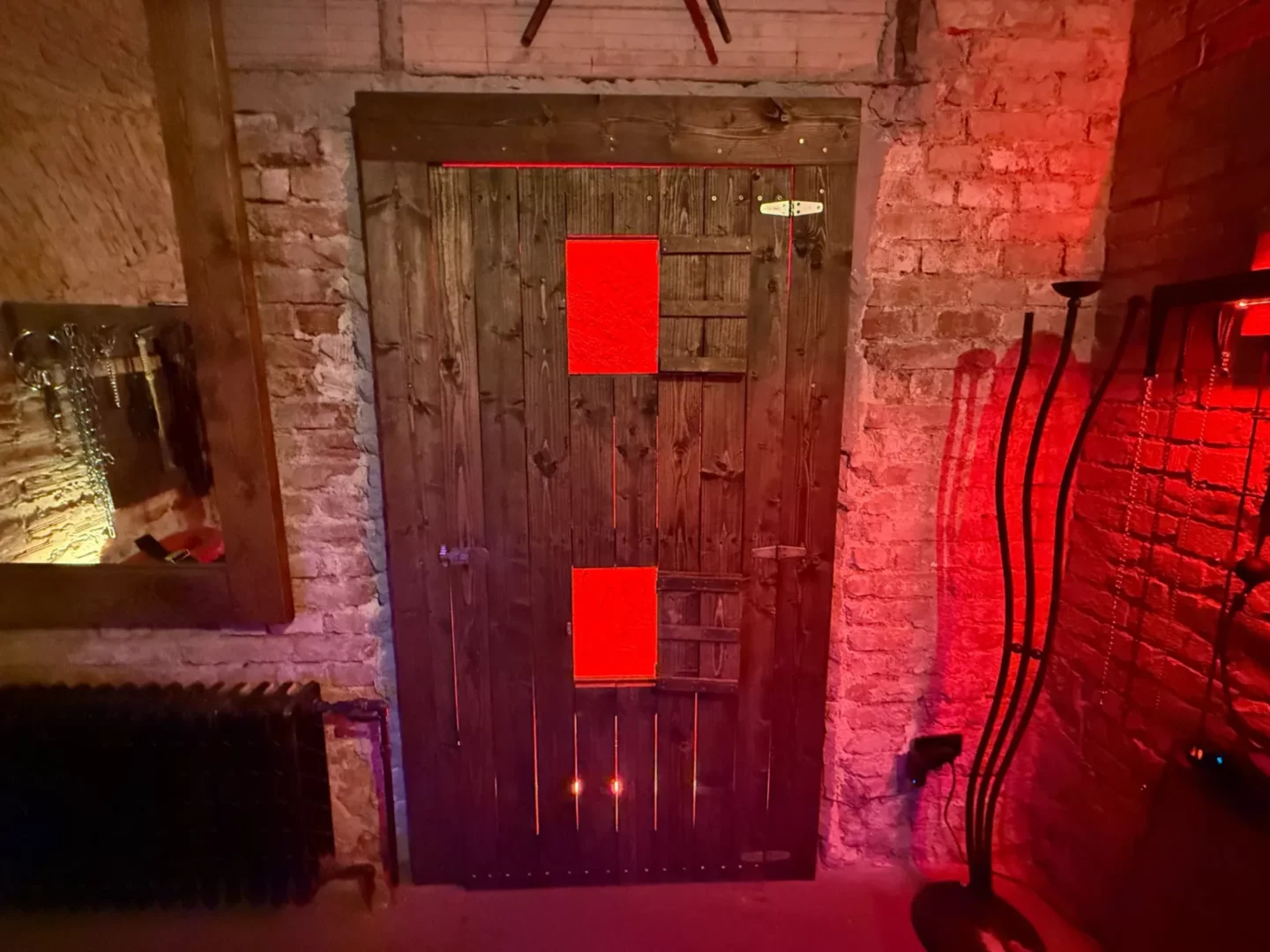 Masivní dřevěné dveře se dvěma prosvícenými gloryhole otvory, BDSM studio Vinohrady, Praha 2