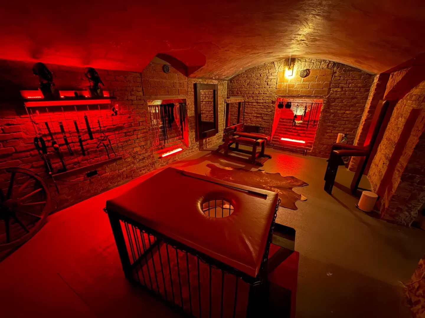 Sklepní mučírna s klecí, lavicí a stěnou plnou pomůcek, BDSM studio Vinohrady, Praha 2