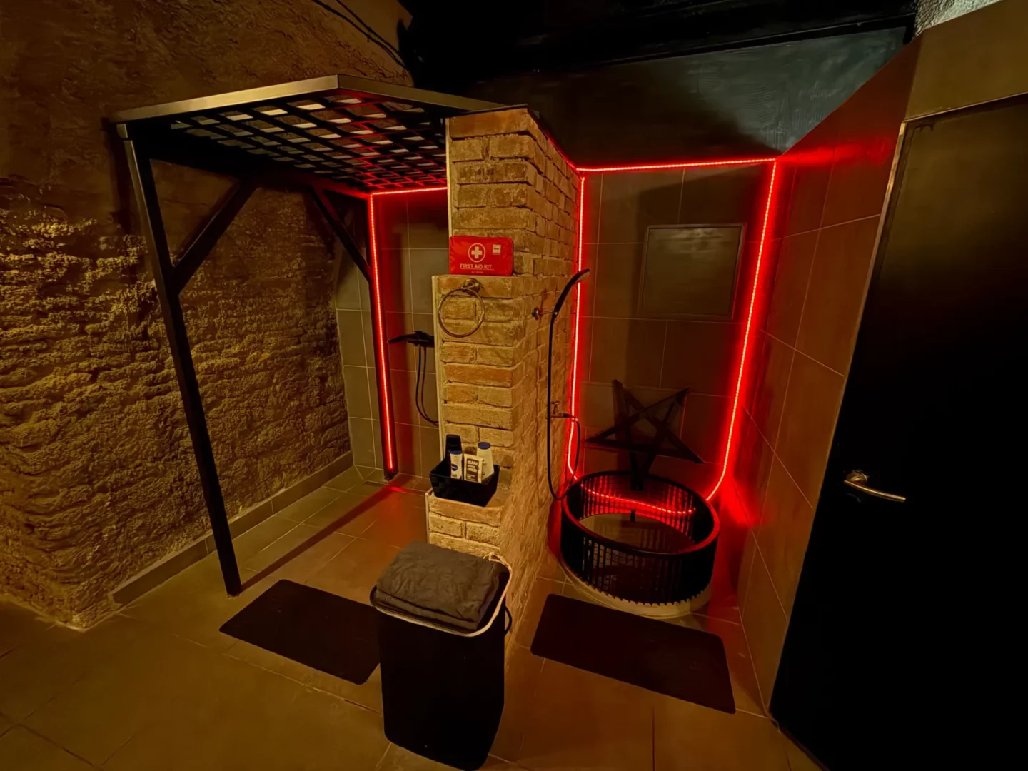 Duschkabine mit Backsteinpfeiler und runder Badewanne mit Pentagramm, BDSM-Studio Karlín, Prag 8